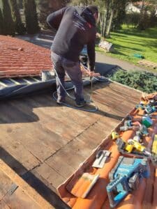artisan qui réalise les finitions d'une isolation sur une toiture